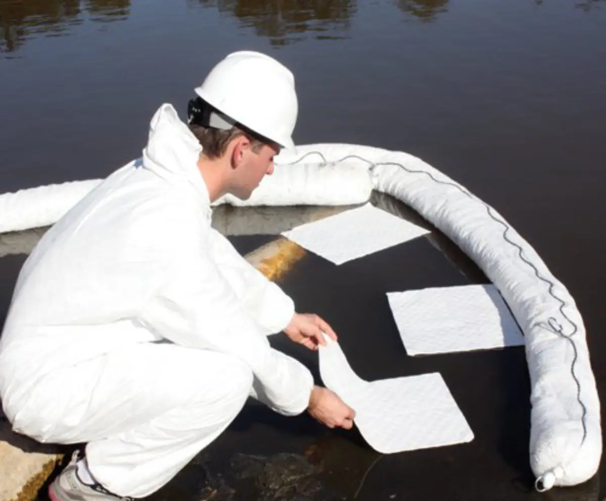 Oil spill containment on water using oil pads and oil booms